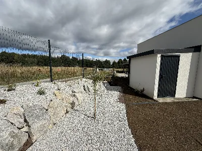 Štrková plocha s kameňmi a výsadbou pozdĺž plota